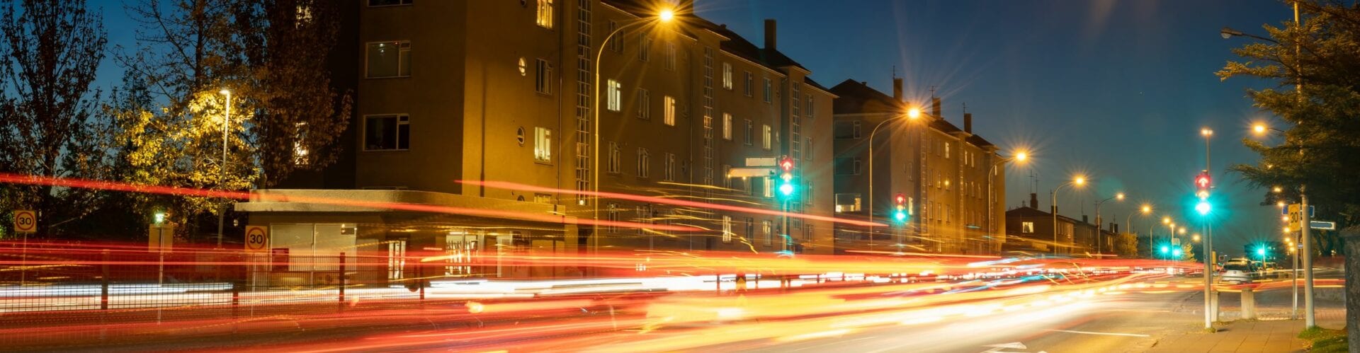 Gata í Reykjavík að kvöldi með ljósrákum frá umferð
